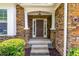 Inviting front entrance featuring a stone facade, covered porch, and classic brown door at 3455 Dalwood Dr, Suwanee, GA 30024