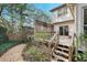 Wooden deck with stairs leading to the yard, surrounded by mature trees and lush greenery at 3923 Ashford Ne Trl, Brookhaven, GA 30319