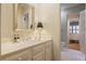 A well-lit bathroom with a white vanity, a decorative lamp, and access to the bedroom at 3923 Ashford Ne Trl, Brookhaven, GA 30319