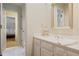 Bright bathroom featuring white cabinetry, a decorative mirror, and an open doorway to the bedroom at 3923 Ashford Ne Trl, Brookhaven, GA 30319