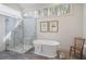 Bathroom featuring an elegant soaking tub, glass enclosed shower, and natural light at 3923 Ashford Ne Trl, Brookhaven, GA 30319