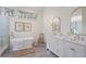 Elegant bathroom with a soaking tub, marble floors, double vanity, and stylish fixtures at 3923 Ashford Ne Trl, Brookhaven, GA 30319