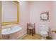 Pink wallpapered powder room with pedestal sink, and a bamboo accent chair at 3923 Ashford Ne Trl, Brookhaven, GA 30319