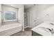 Bright bathroom featuring a soaking tub, glass enclosed shower and double sink vanity at 5063 Lower Elm St, Atlanta, GA 30349