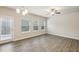 An open living area with light hardwood floors, a ceiling fan and lots of windows at 5063 Lower Elm St, Atlanta, GA 30349