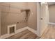 This laundry room features a wire shelf above the washer/dryer hookups and luxury vinyl plank flooring at 577 Center Hill Nw Ave, Atlanta, GA 30318