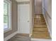 View of a staircase with wooden steps and a handrail, next to a closed, white door and a window at 577 Center Hill Nw Ave, Atlanta, GA 30318