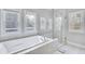 Elegant bathroom featuring a soaking tub and frameless glass shower, accented by bright natural light at 2304 Isla Run, Woodstock, GA 30188