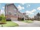 Three-story townhome featuring brick accents, two car garage, and a private balcony at 2304 Isla Run, Woodstock, GA 30188