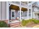 Inviting front porch with brick accents, white railing, and comfortable seating; perfect for relaxing at 2304 Isla Run, Woodstock, GA 30188