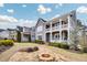 Landscaped front yard with a cozy stone fire pit and a charming two-story home with a double-decker porch at 2304 Isla Run, Woodstock, GA 30188