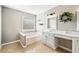 Bright bathroom featuring a garden tub, vanity with sink and tiled floor at 6280 Whirlaway Dr, Cumming, GA 30040