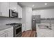 Kitchen featuring stainless steel appliances, white cabinets, granite countertops, and a center island at 100 Duval Dr, Alpharetta, GA 30009