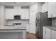 Kitchen featuring stainless steel appliances, white cabinets, granite countertops, and a center island at 100 Duval Dr, Alpharetta, GA 30009