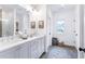 Bathroom featuring double sinks, shaker cabinets, and a large window with a neighborhood view at 3326 Springhaven Ave, Hapeville, GA 30354