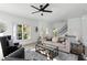 Bright and airy living room featuring a ceiling fan, two side tables and staircase at 3326 Springhaven Ave, Hapeville, GA 30354