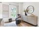 Bright main bedroom featuring artwork, a round mirror, hardwood floors, and a cozy chair at 3326 Springhaven Ave, Hapeville, GA 30354