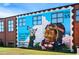 Vibrant mural art on a brick building showing a Personal with goggles holding a plane at 3326 Springhaven Ave, Hapeville, GA 30354