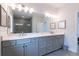 Elegant bathroom featuring double vanity, gray cabinets, quartz countertop, and a large mirror reflecting the walk-in shower at 4374 Benfield Se Way # 1801Lo, Smyrna, GA 30080