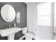 Charming powder room with gray subway tile, modern pedestal sink, and round mirror at 4374 Benfield Se Way # 1801Lo, Smyrna, GA 30080