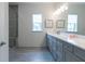 Bathroom featuring double vanity, gray cabinets, quartz countertop, large mirror, and stylish light fixtures at 4374 Benfield Se Way # 1801Lo, Smyrna, GA 30080