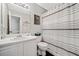 Well-lit bathroom featuring white vanity, toilet, and shower with black and white striped curtain at 565 Saint James Ct, Lawrenceville, GA 30044