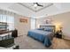 Bright bedroom features carpet, ceiling fan, and a tray ceiling with primary bed, vanity and sitting chair at 565 Saint James Ct, Lawrenceville, GA 30044