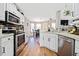 Well-lit kitchen featuring white cabinets, stainless steel appliances, and open layout at 565 Saint James Ct, Lawrenceville, GA 30044