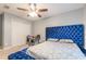 Bright bedroom with a tufted blue bed frame, double door closet, and a ceiling fan at 970 Sidney Marcus Blvd # 1217, Atlanta, GA 30324