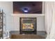 Close-up of the fireplace with a black tile surround and mantel, beneath mounted television at 970 Sidney Marcus Blvd # 1217, Atlanta, GA 30324