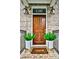 Inviting front door with decorative planters and brick accents, enhancing curb appeal at 1180 John Collier Rd, Atlanta, GA 30318