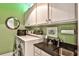 Well-organized laundry room with white cabinets, countertop space, and modern washer and dryer at 1180 John Collier Rd, Atlanta, GA 30318