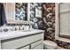 Chic half bath featuring a designer wallpaper, a marble countertop, and stylish fixtures at 1180 John Collier Rd, Atlanta, GA 30318