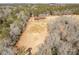 An aerial view captures the structure and field nestled in a scenic, wooded area at 1570 Butler Bridge Rd, Covington, GA 30016