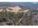 This aerial view showcases a combination of woods, pastureland, and an access road at 1570 Butler Bridge Rd, Covington, GA 30016