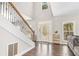 Bright foyer with hardwood floors, staircase with iron spindles, and transom windows above the entryway at 1570 Butler Bridge Rd, Covington, GA 30016