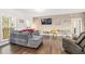 Living room with hardwood floors, gray sofa with red pillows, and large windows for natural light at 1570 Butler Bridge Rd, Covington, GA 30016