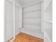 Walk-in closet with white walls, wood floor, and built-in shelving at 1570 Butler Bridge Rd, Covington, GA 30016