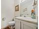 Powder room featuring a white vanity, framed artwork, and patterned rug at 1675 Paddlewheel Dr, Marietta, GA 30062