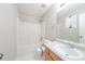 Bathroom featuring a bathtub with shower, toilet, white tile flooring and single sink vanity with storage underneath at 2397 Shady Maple Trl, Loganville, GA 30052