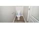 A bathroom featuring a toilet, wood look flooring, and a door at 2397 Shady Maple Trl, Loganville, GA 30052