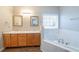 Bathroom featuring double sinks, a soaking tub, and natural light at 2397 Shady Maple Trl, Loganville, GA 30052