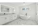 Spa-like bathroom featuring a soaking tub, marble floors, and double vanity at 438 Ansley St, Decatur, GA 30030