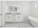 Bright, modern bathroom with a soaking tub, double vanity, and marble floors at 438 Ansley St, Decatur, GA 30030