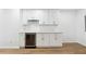 Modern wet bar with white cabinets, wine cooler, and light countertops at 438 Ansley St, Decatur, GA 30030