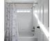 Bathroom with a bathtub and shower, featuring white tile and good natural light at 2560 Millwater Xing, Dacula, GA 30019