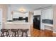 Bright kitchen with white cabinets, black appliances, and bar seating on hardwood floors at 2560 Millwater Xing, Dacula, GA 30019