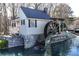 Scenic view of a charming water mill house, featuring stone foundations and a classic water wheel at 2560 Millwater Xing, Dacula, GA 30019