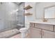 Bathroom featuring herringbone tile shower, floating shelves, and a modern vanity with gold fixtures at 3927 Enclave Way, Tucker, GA 30084