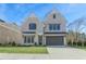 Elegant two-story home featuring a light brick facade, a two-car garage, and a well-manicured lawn at 3927 Enclave Way, Tucker, GA 30084
